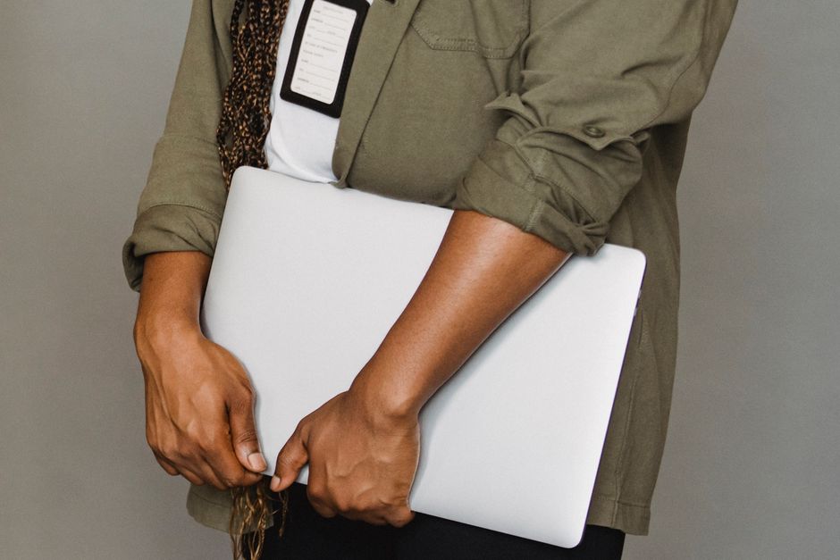 Pessoa segurando um laptop e smartphone, indicada para temas de tecnologia e produtividade no ambiente de trabalho.