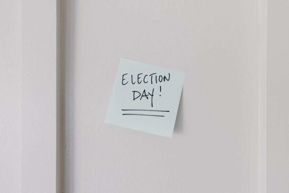 Post-it na parede com mensagem sobre o dia de eleições, destacando o tema de processos democráticos e participação cívica.