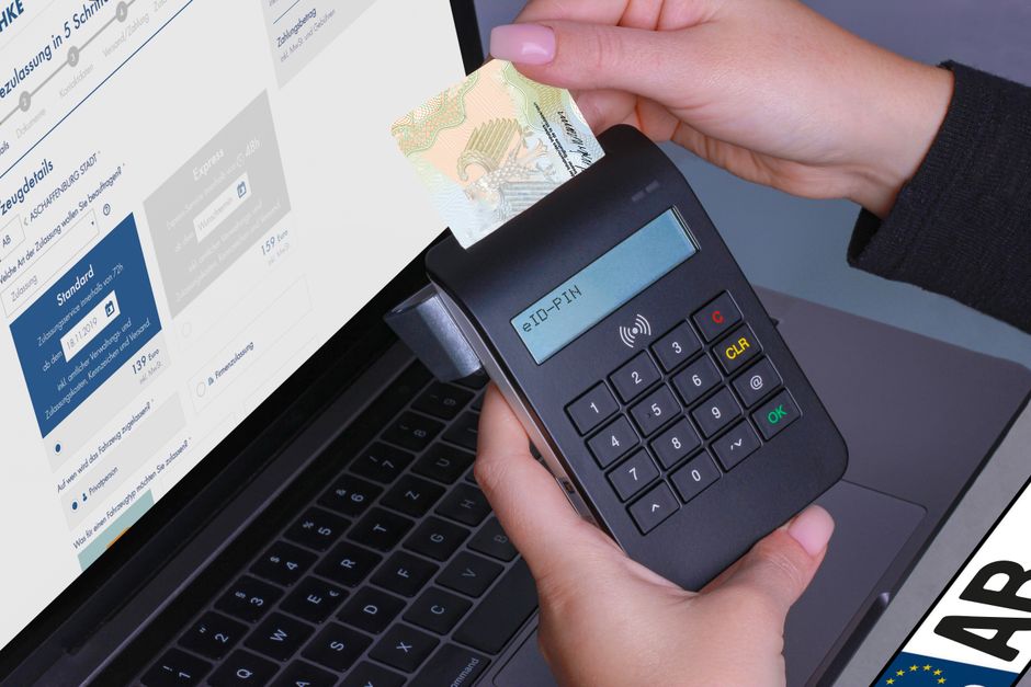 Pessoa realizando pagamento eletrônico com cartão de crédito usando um leitor de cartões conectado ao computador, representando tecnologia financeira e transações digitais.