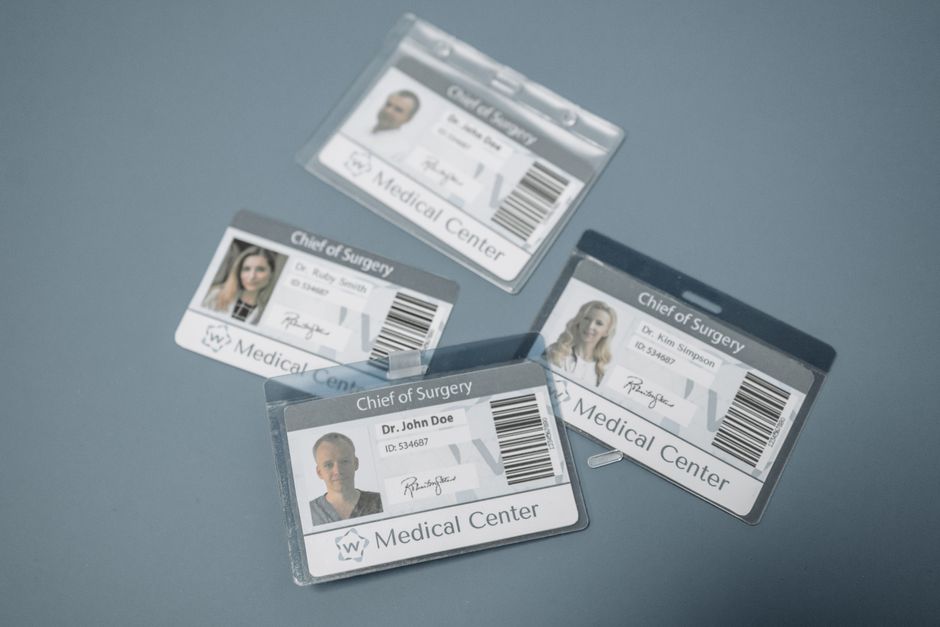 Placas de identificação de profissionais médicos exibidas em uma mesa de centro, simbolizando hospitais ou centros cirúrgicos.