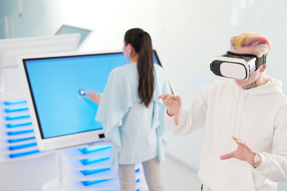Pessoas utilizando tecnologia avançada, incluindo realidade virtual, em um ambiente de inovação e inovação digital.