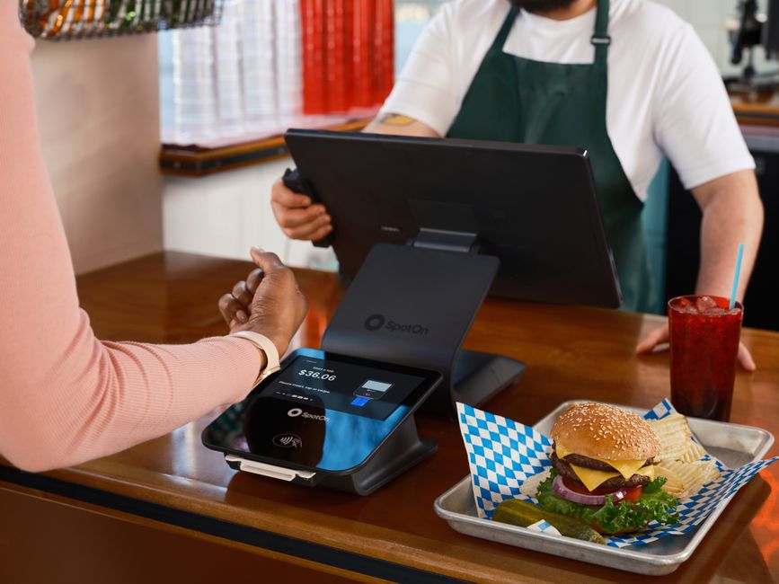Cliente realizando pagamento eletrônico em restaurante com pagamento por aproximação, destacando a tecnologia de transações digitais na gastronomia.