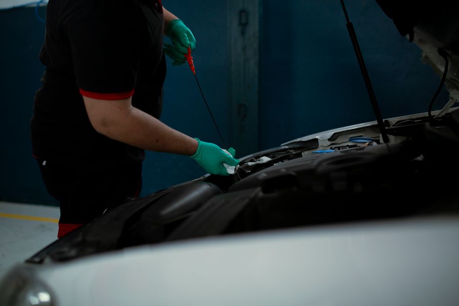 Técnico realizando manutenção em um carro, representando cuidado e precisão na área automotiva.