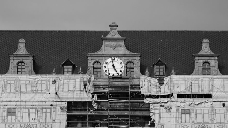 Edifício histórico em restauração, com escavações e andaimes, simbolizando preservação e renovação arquitetônica.