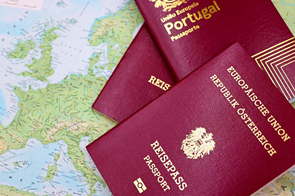 Foto de passaportes portugueses e europeus sobre um mapa, simbolizando viagem internacional e documentação de viagem.