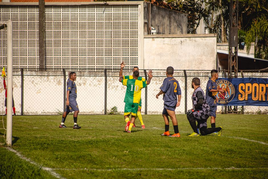 Jogadores de futebol comemorando um gol em campo durante uma partida, demonstrando emoção e celebração esportiva.
