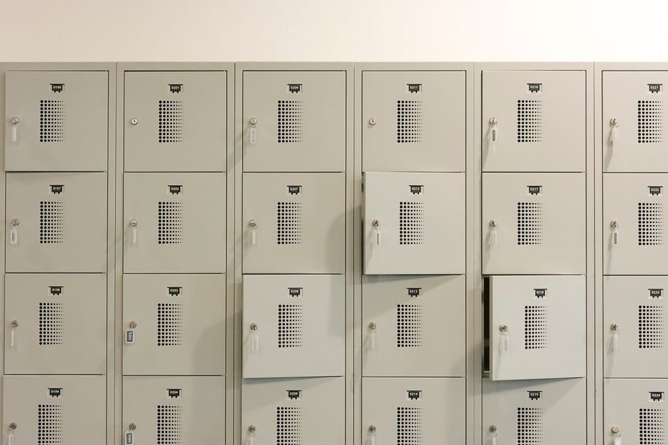 Arquivo de armários de depósito com portas numeradas e cadeados, simbolizando organização e segurança em ambientes empresariais.