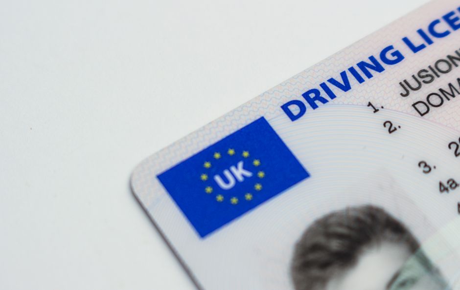 Imagem de uma carteira de motorista do Reino Unido, focando no documento de habilitação com destaque para o selo da União Europeia ao lado da sigla UK.