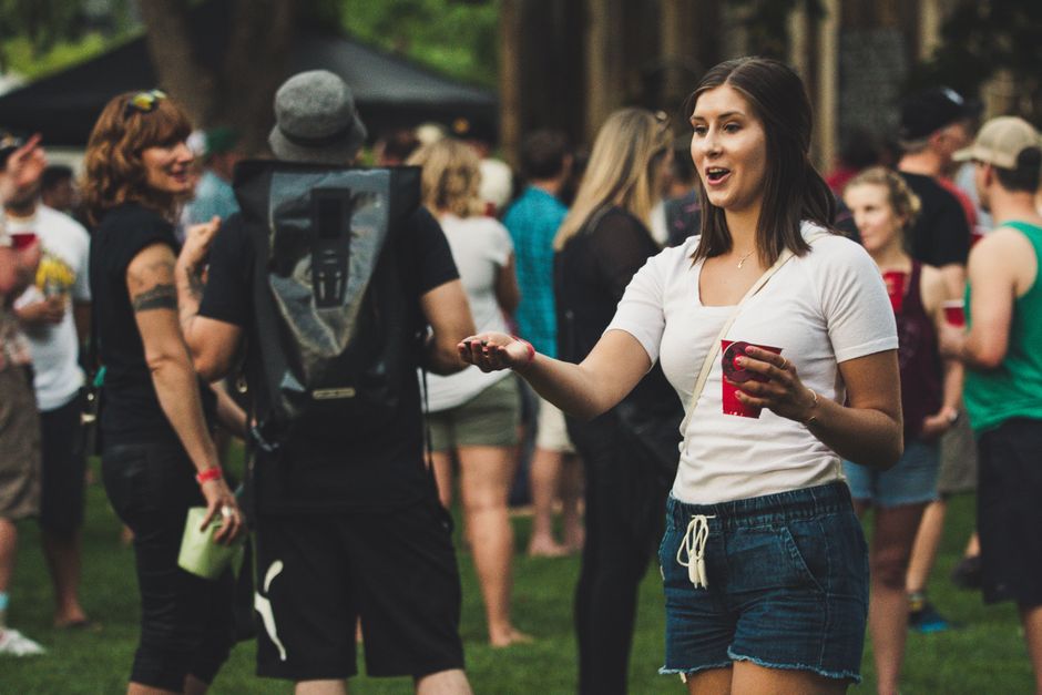 Mulher interagindo com amigos em um evento social ao ar livre, transmitindo conexão e diversão.
