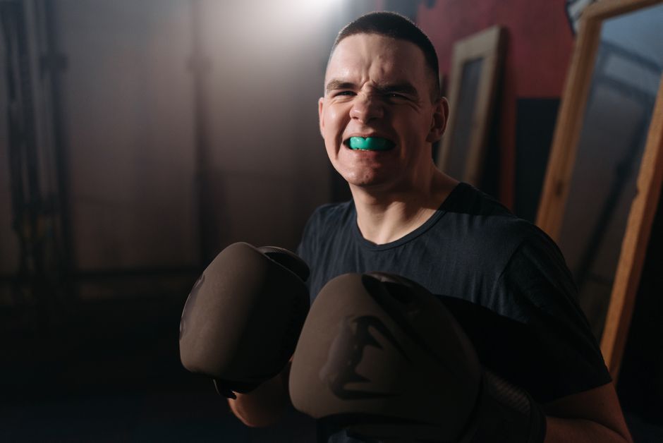 Jovem mostrando determinação e força ao usar luvas de boxe, simbolizando superação de obstáculos.