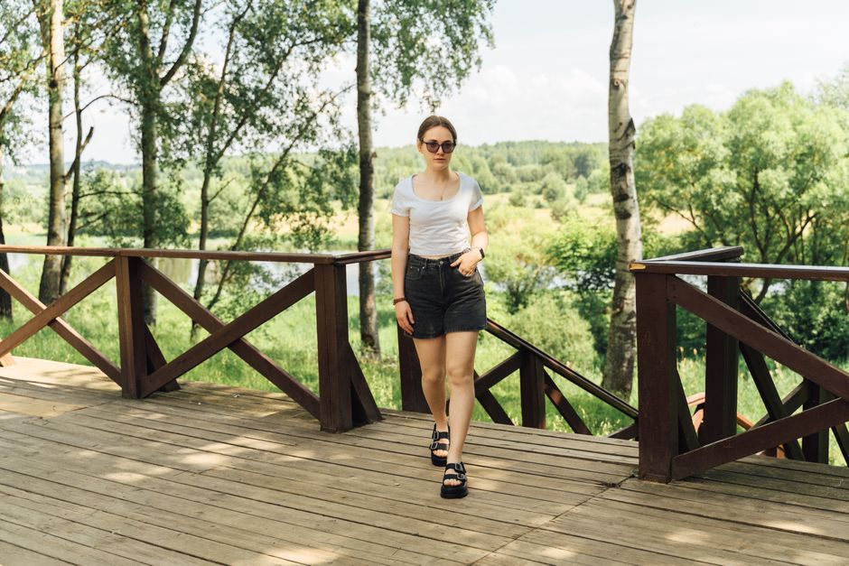 Mulher caminhando ao ar livre, aproveitando um momento de lazer na natureza durante um dia ensolarado.