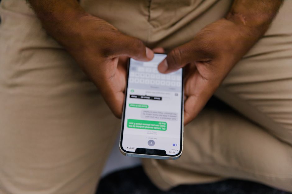 Pessoa usando smartphone para comunicação, com foco em tecnologia móvel e conectividade.