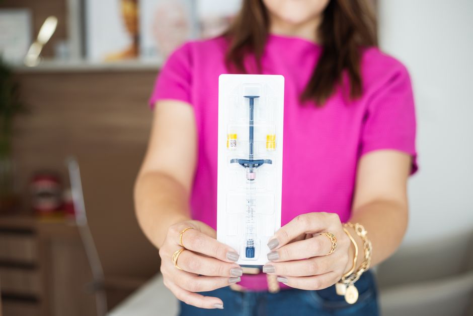 Mulher segurando um kit de teste de glicemia, representando cuidados com a saúde, controle de diabetes ou monitoramento glicêmico.