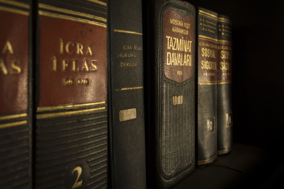Imagem de uma estante com livros jurídicos e de direito, simbolizando estudos ou pesquisa na área legal.