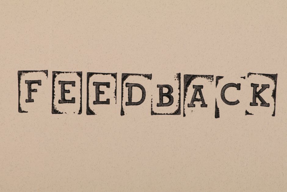 Imagem com blocos de impressão formando a palavra 'FEEDBACK', simbolizando a importância do retorno e aprimoramento em ambientes de trabalho ou educação.
