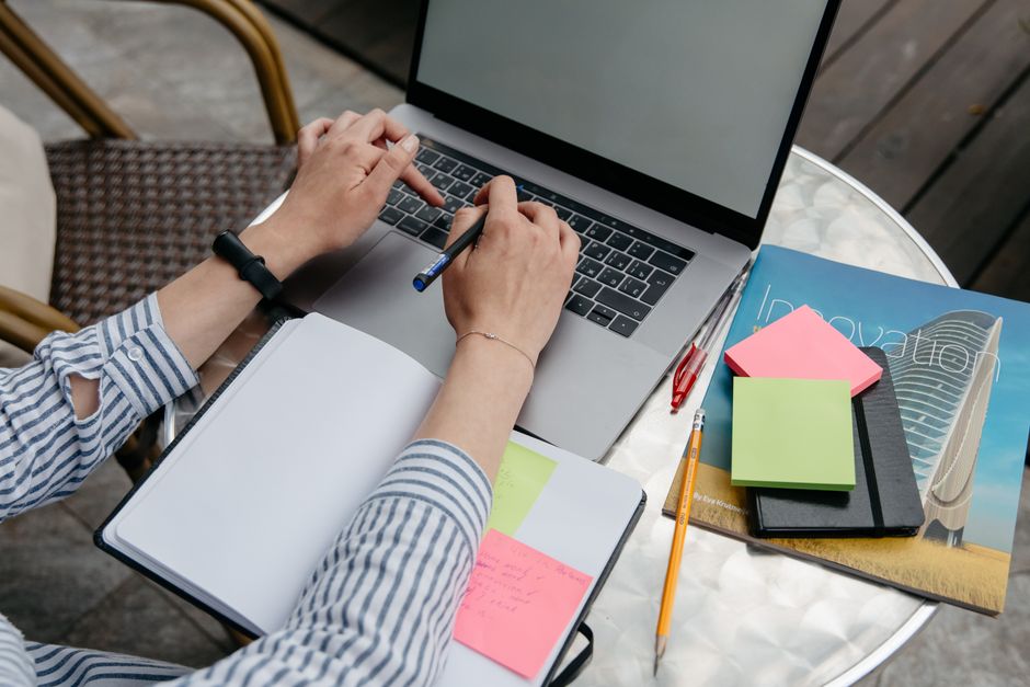 Pessoa trabalhando de forma organizada com materiais de escritório em um ambiente que sugere foco em planejamento e produtividade.