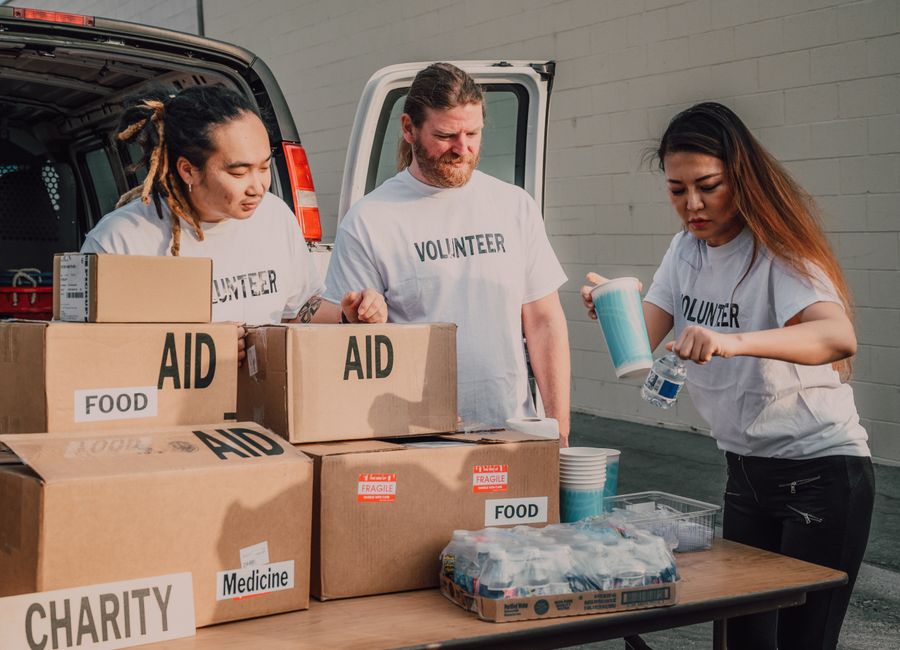 Voluntários organizando doações de alimentos e suprimentos para uma ação solidária.