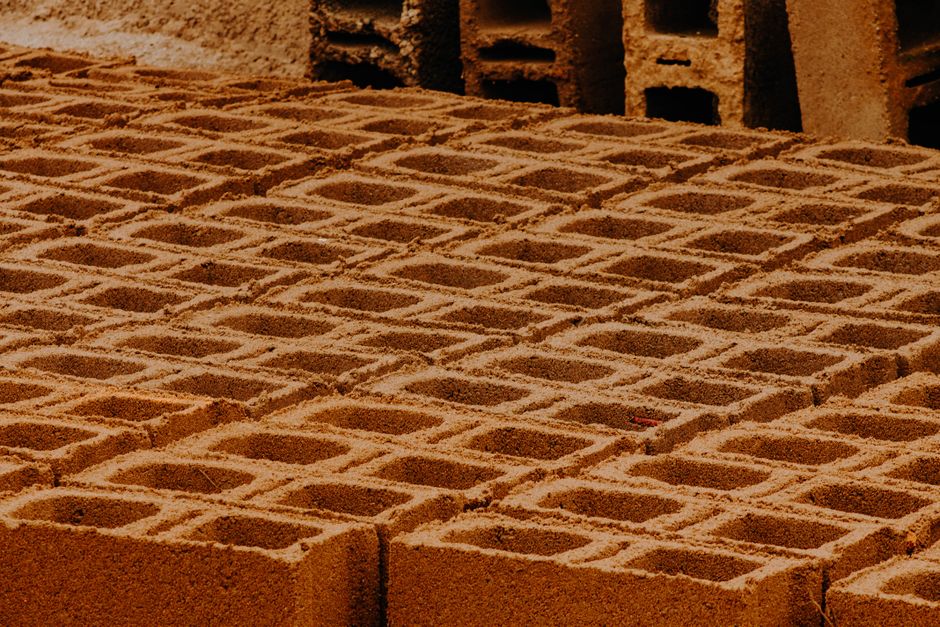 Imagem de tijolos sendo colocados para a construção de uma parede, destacando o processo de alvenaria.