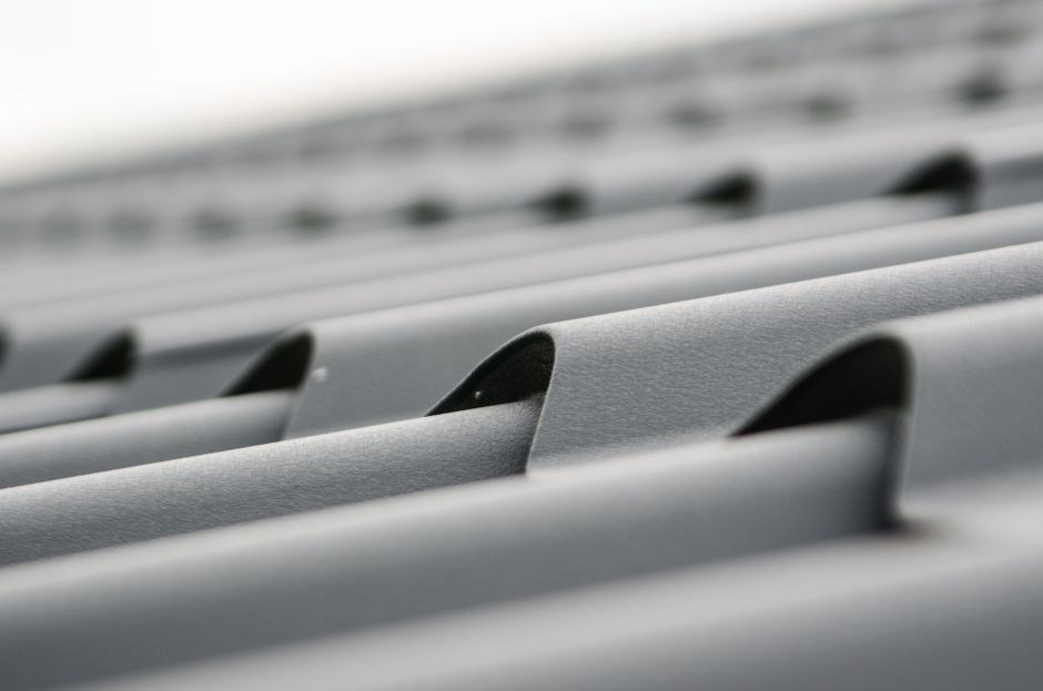 Imagem de várias telhas de telhado de metal, destacando a textura e o design da cobertura.