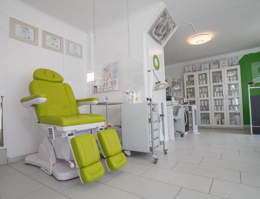 Sala de atendimento odontológico moderna com cadeira azul, equipamentos médicos e mobiliário organizado, pronta para atender pacientes.