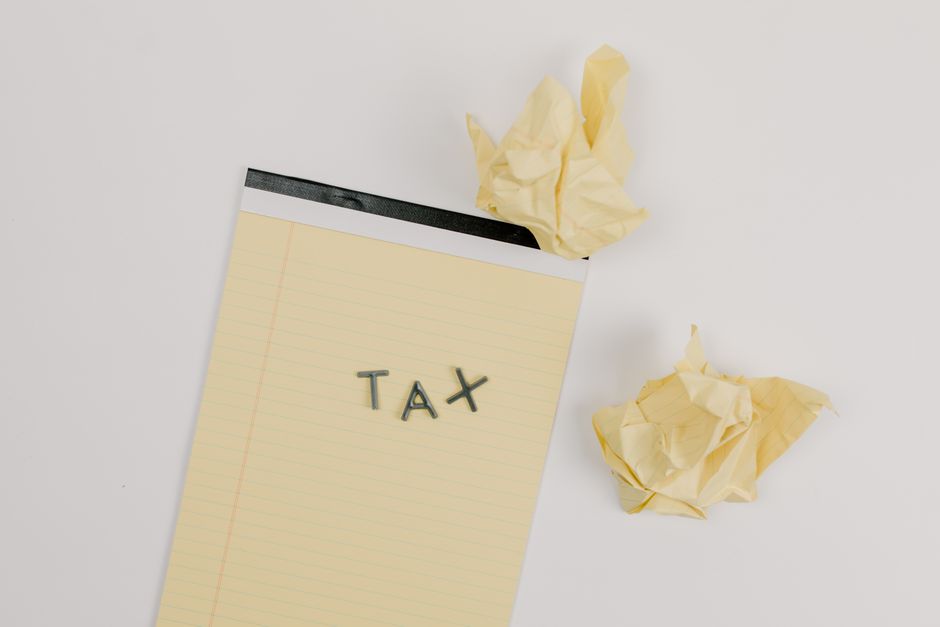 Imagem representando a preocupação com a declaração de impostos, com papel amassado e uma nota com a palavra 'TAX' em destaque, ideal para artigos sobre obrigações fiscais e contabilidade.