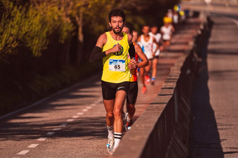 Grupo de corredores participando de uma corrida ao ar livre durante o pôr do sol, enfatizando o esporte e a atividade física.