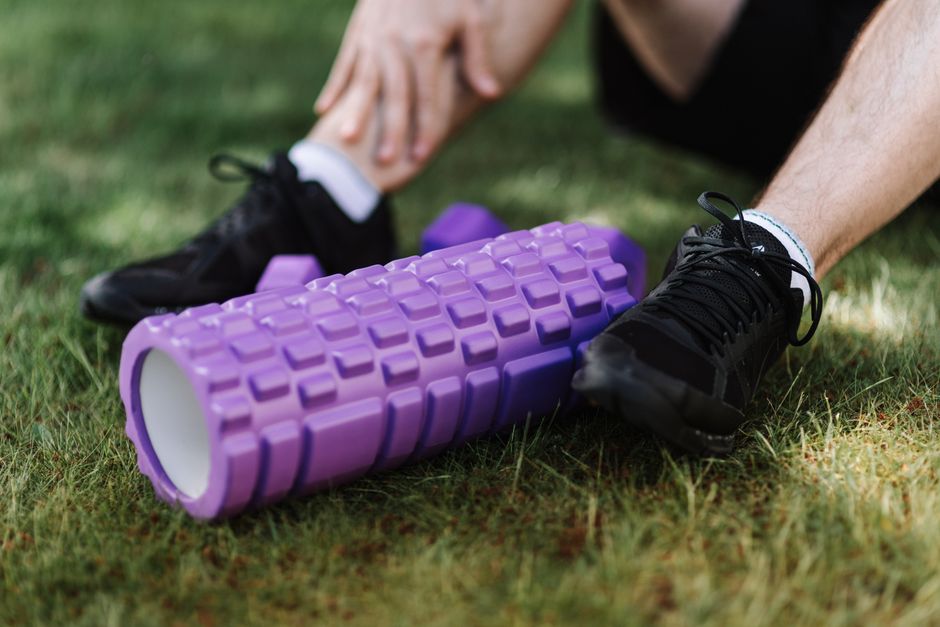 Pessoa usando equipamentos de alongamento e fortalecimento na prática de exercícios físicos ao ar livre, focando na preparação muscular.