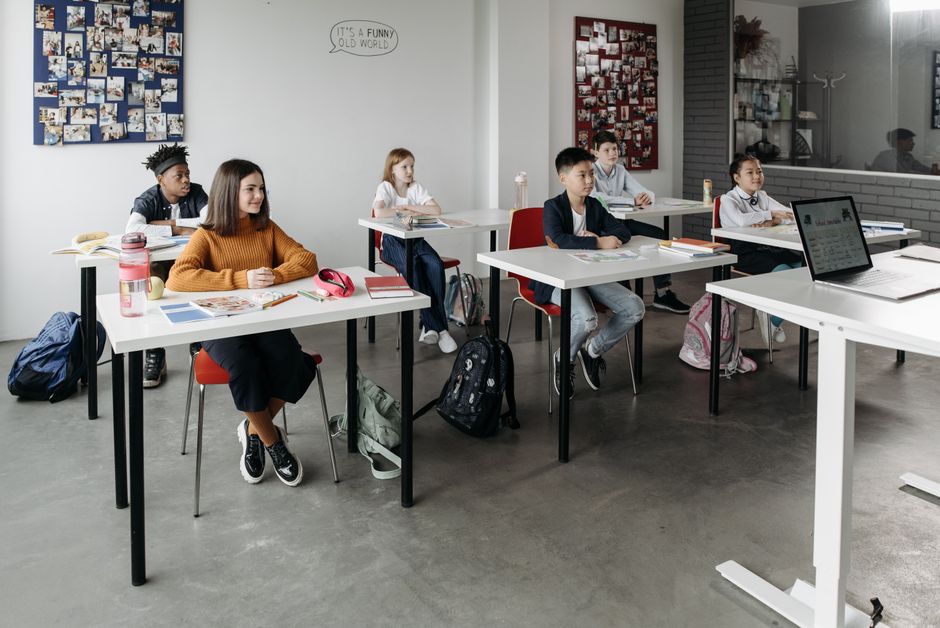 Grupo de crianças em sala de aula, focadas e participativas, durante uma atividade escolar.