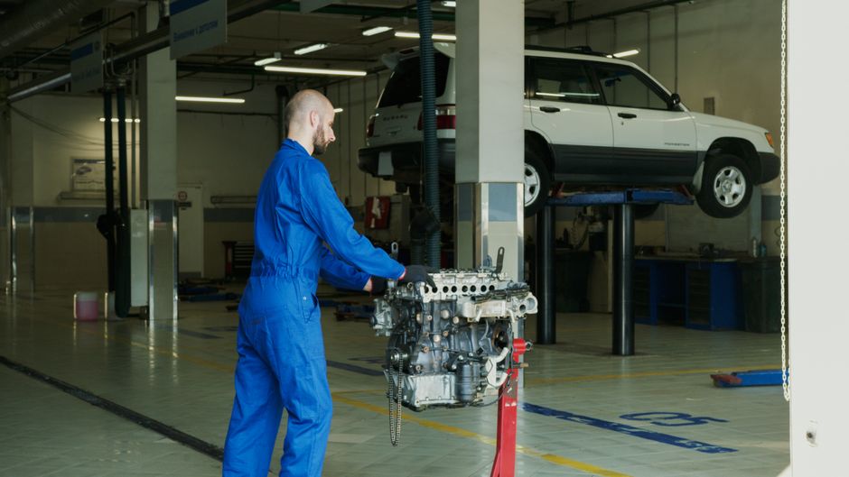 Profissional examinando um automóvel elevado numa oficina