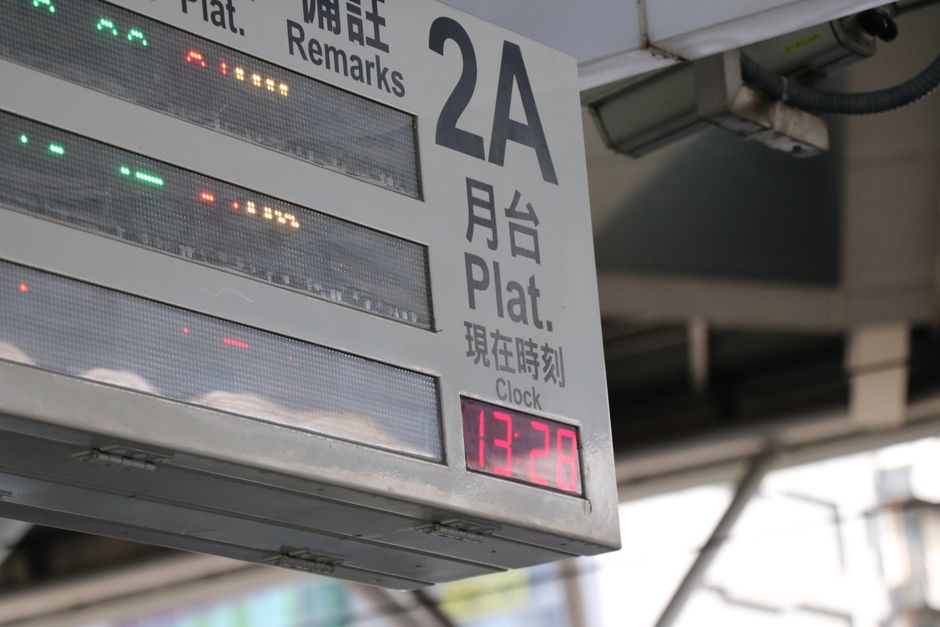 Imagem de um painel digital de informações em um terminal de transporte, exibindo horário e detalhes de embarque ou chegada.