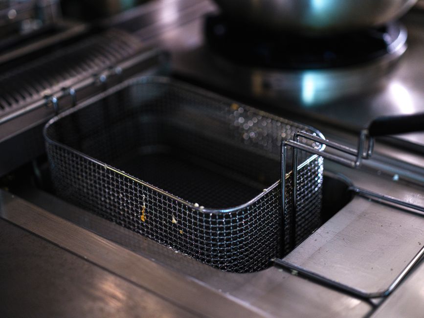 Imagem de uma fritadeira sem óleo sendo preparada para uso em uma cozinha profissional, destacando a tecnologia de cozinha saudável.