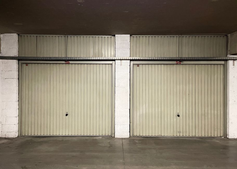 Imagem de uma garagem com portas de aço em ambiente de estacionamento, destacando a organização e segurança dos espaços de armazenamento.