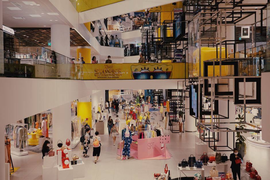 Imagem de um shopping movimentado com diversas lojas e visitantes explorando o local, ideal para artigos sobre consumo, varejo e experiência de compra.