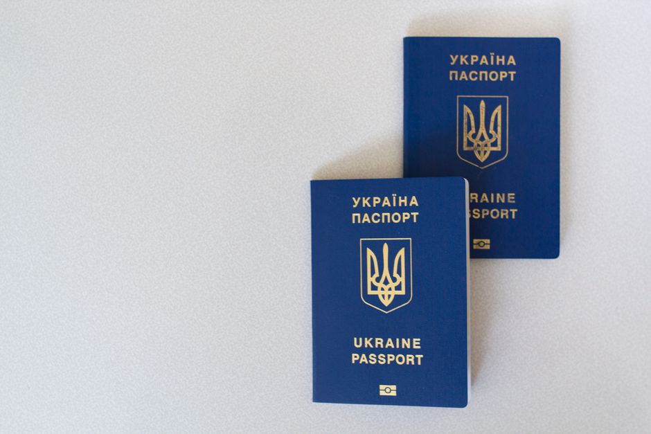 Imagem de dois passaportes ucranianos sobre uma superfície clara, simbolizando temas relacionados a viagens internacionais ou documentação de cidadãos ucranianos.