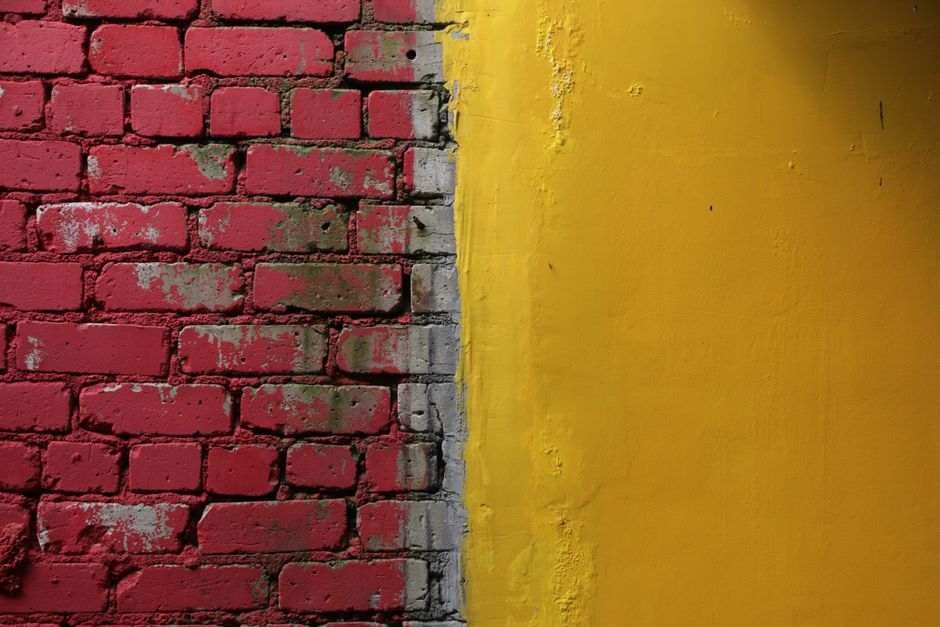 Parede dividida em duas cores vibrantes, vermelha e amarela, criando um contraste visual marcante.