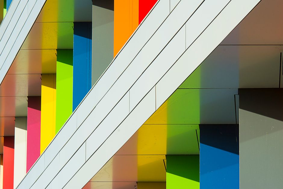 Imagem de uma fachada moderna de edifício com painéis coloridos, destacando o design arquitetônico vibrante e contemporâneo.