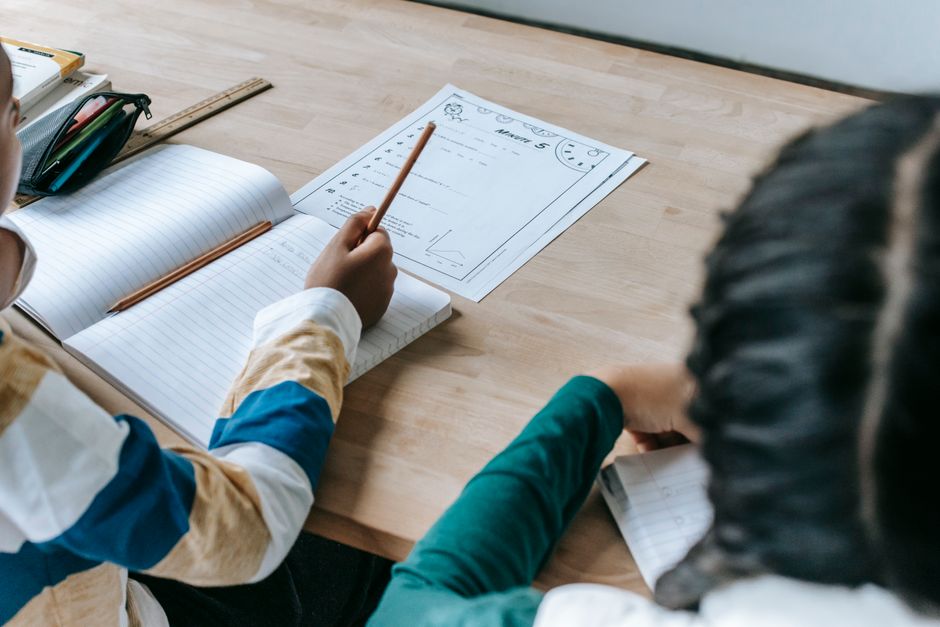 Pessoas estudando planejamento financeiro ou gestão de projetos em uma mesa de trabalho.