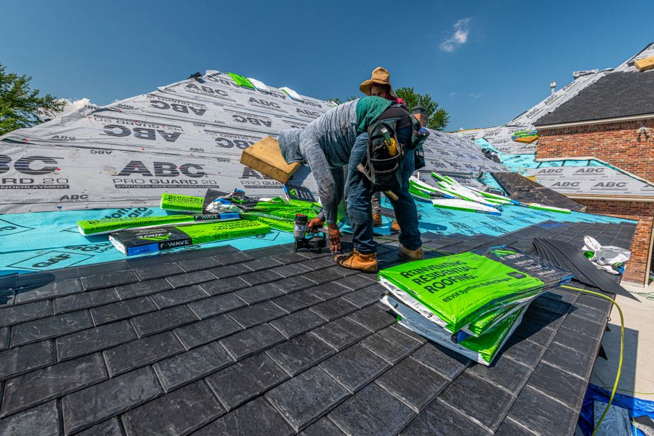 Profissional instalando materiais de isolamento térmico em um telhado, representando melhorias na eficiência energética de edificações.