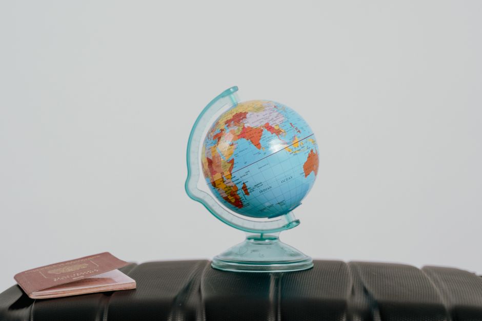 Globo terrestre sobre uma superfície em um ambiente de estudo ou trabalho, simbolizando globalização, educação ou viagens.