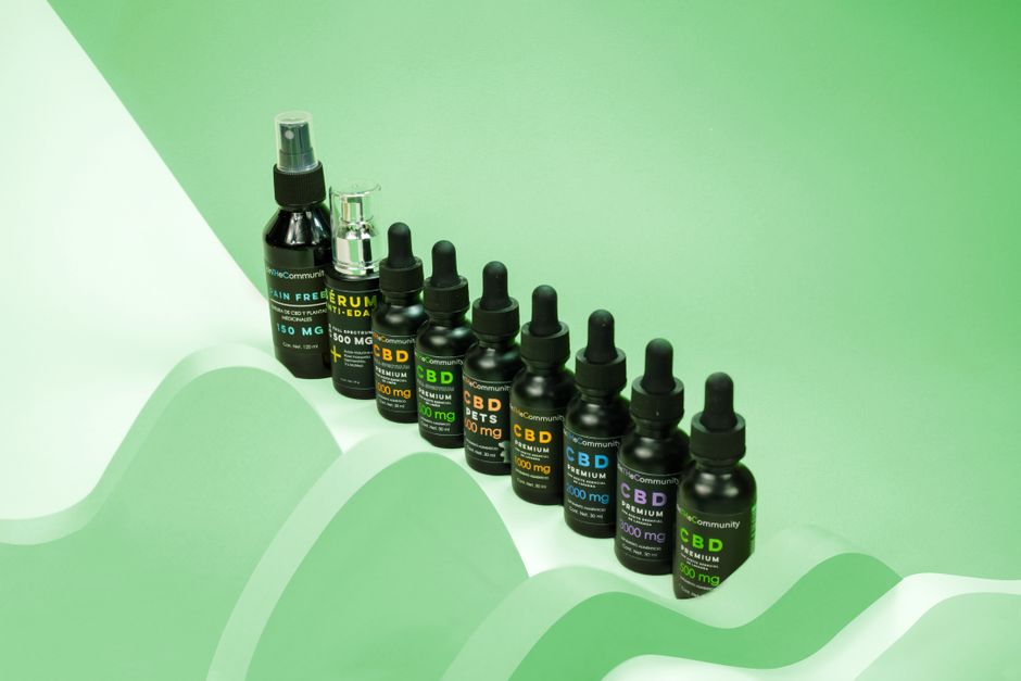 Imagem de frascos e gotas de CBD em um fundo verde, remetendo ao tema de bem-estar e saúde natural.