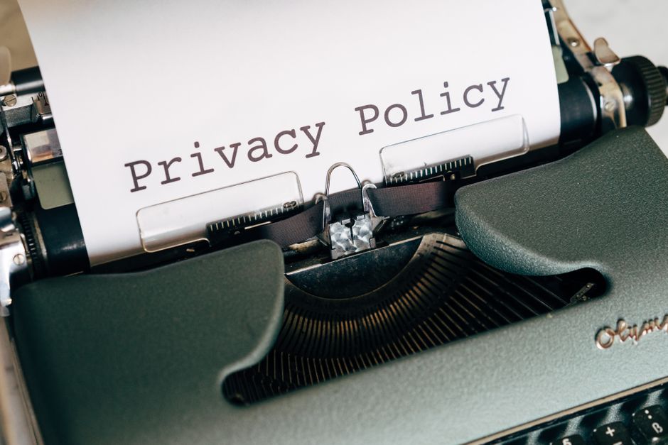 Imagem de uma máquina de escrever com uma folha de papel exibindo o texto 'Privacy Policy', representando a importância da proteção de dados e privacidade na era digital.