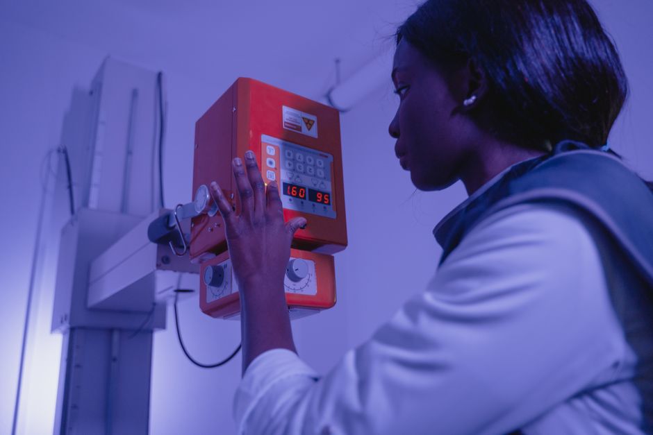 Profissional ajustando um equipamento de emergência em uma sala de hospital, simbolizando trabalho na área de saúde e segurança.