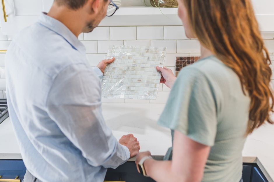 Pessoas discutindo opções de revestimento de azulejos para um projeto de decoração de interiores.