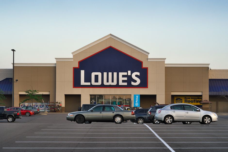Fachada de uma loja Lowe's em um shopping com carros na frente, representando o setor de reformas e construção civil.