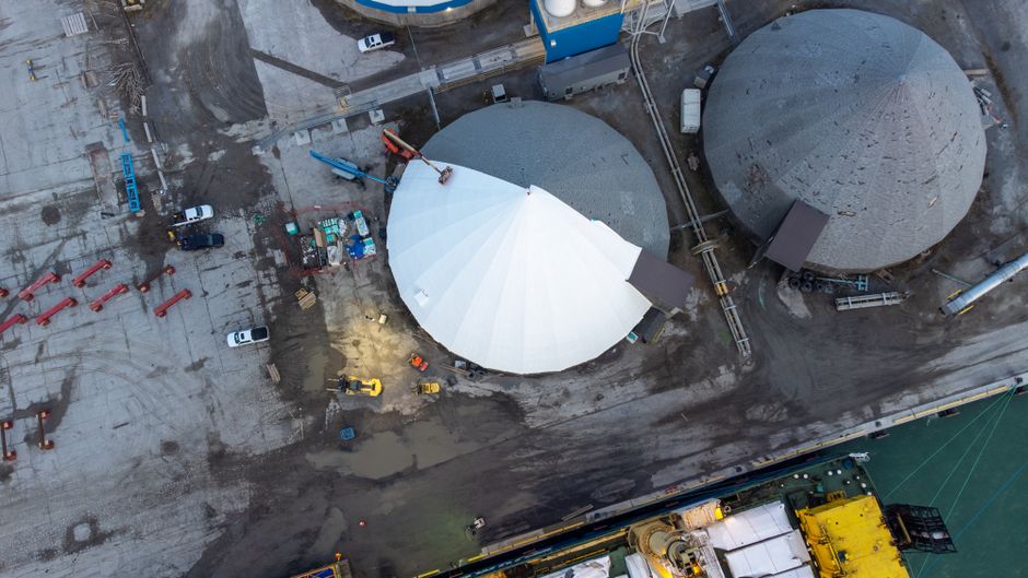 Visão aérea de uma usina de produção de energia, destacando suas estruturas e equipamentos.