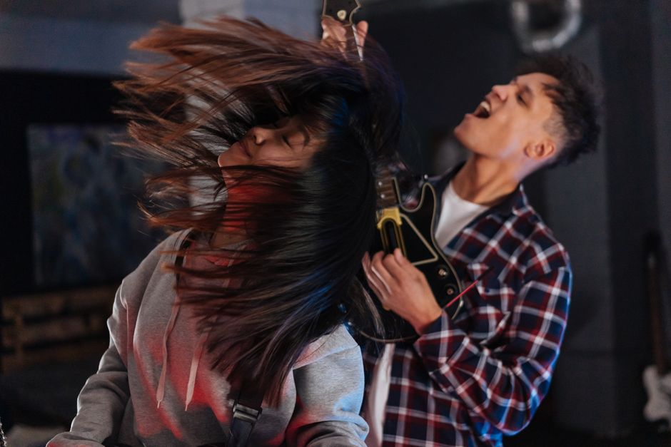 duas pessoas curtindo uma apresentação musical com energia e movimento, evidenciando emoção e diversão