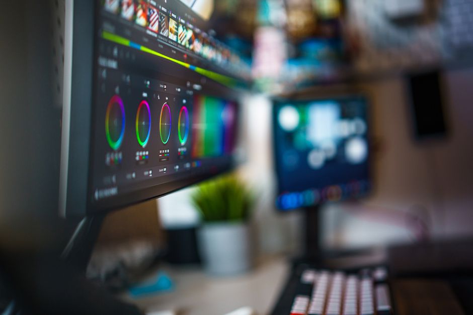 Imagem de uma estação de trabalho com monitores exibindo ferramentas de edição de vídeo ou design gráfico, ideal para um artigo sobre criação de conteúdo digital ou edição de vídeos.