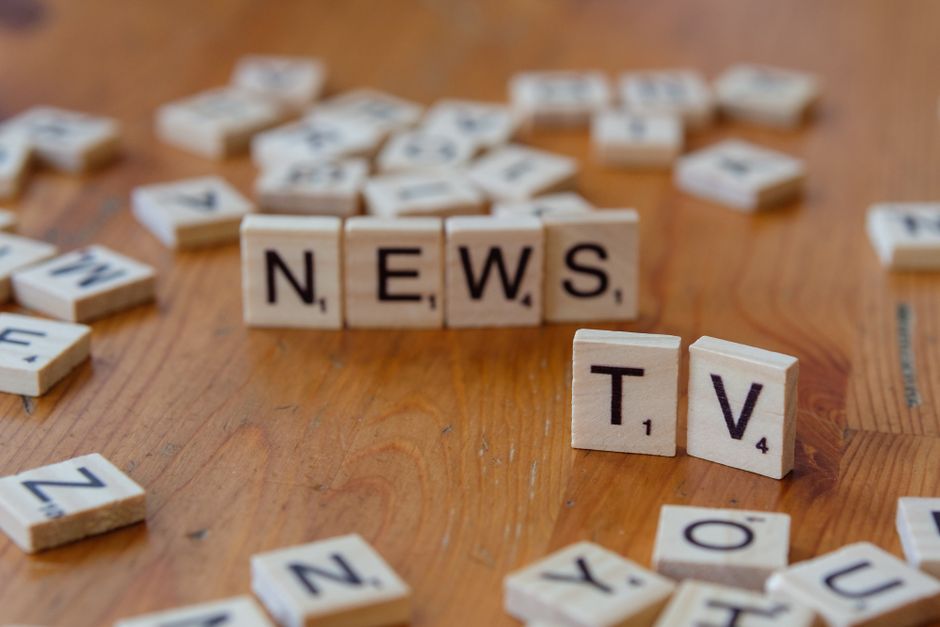 Imagem com blocos de palavras formando a palavra 'NEWS', simbolizando atualização ou novidades, em um ambiente de lazer ou estudo.