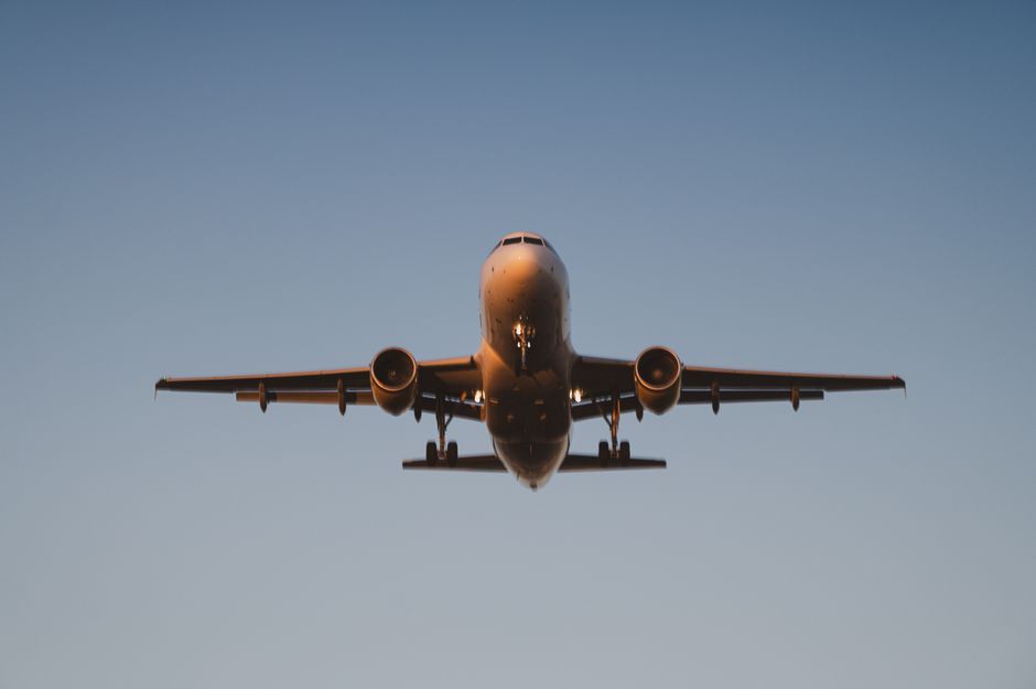 Avião em voo de grande altitude durante o entardecer, simbolizando viagens aéreas e transporte internacional.