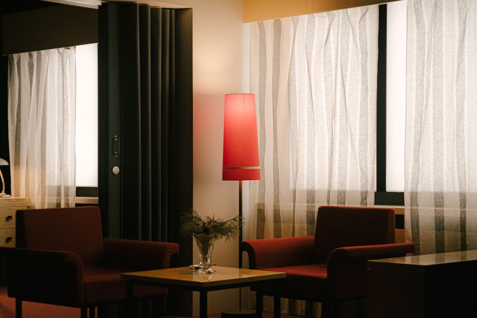 Ambiente aconchegante de sala de estar com iluminação indireta e móveis confortáveis, ideal para descanso ou leitura.